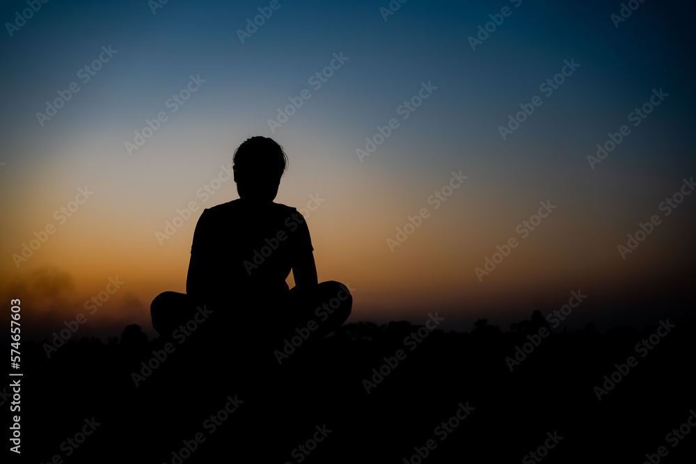 Silhouette of a woman sitdown with so sad in the sunset.