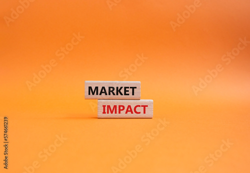 Market impact. Concept word Market impact on wooden cubes. Beautiful orange background. Business and Market impact concept. Copy space.