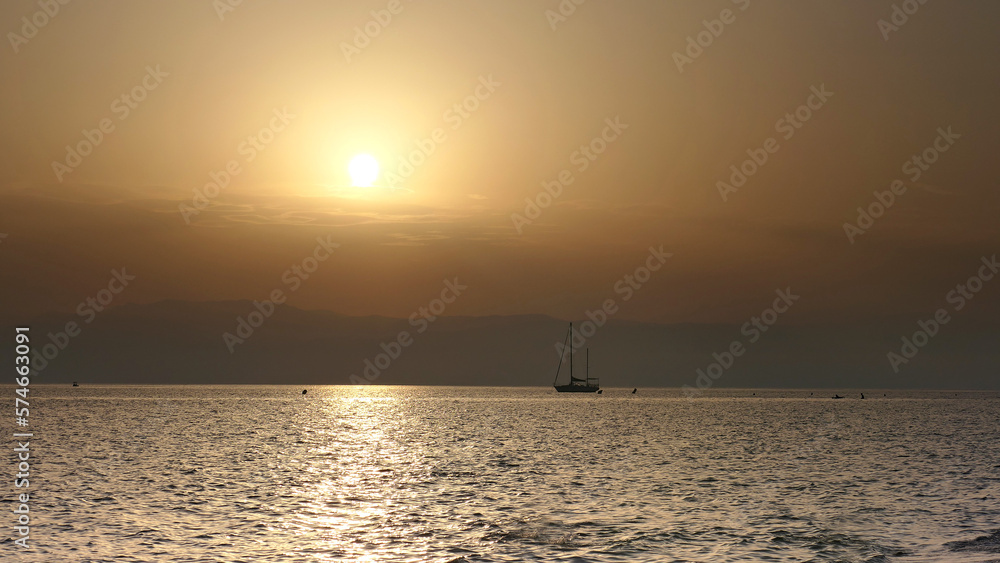 Beautiful sailboat with sunset at sunset in the ocean