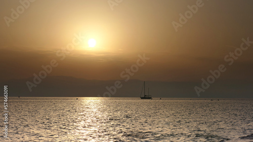 Beautiful sailboat with sunset at sunset in the ocean © juan cesar