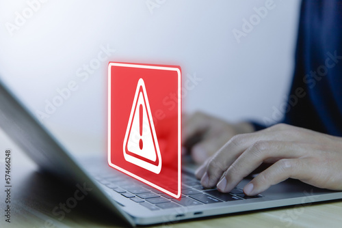 Fototapeta Naklejka Na Ścianę i Meble -  Businessman using laptop showing warning triangle and exclamation sign icon caution of dangerous problems server error	