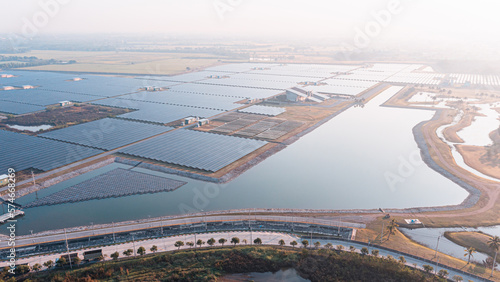 Solar Photovoltaic of solar farm aerial view, solar plant rows array of on the water mount system Installation in earthen pond, Floating solar or floating photovoltaics (FPV). Morning scene,