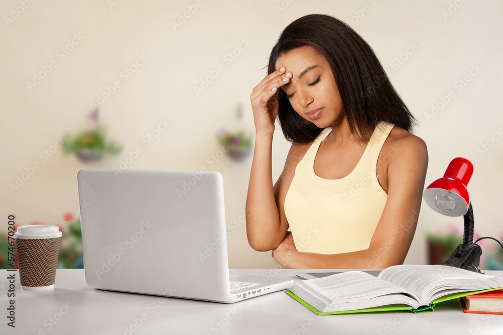 Frustrated sad girl works on laptop computer Frustrated sad girl works on laptop computer