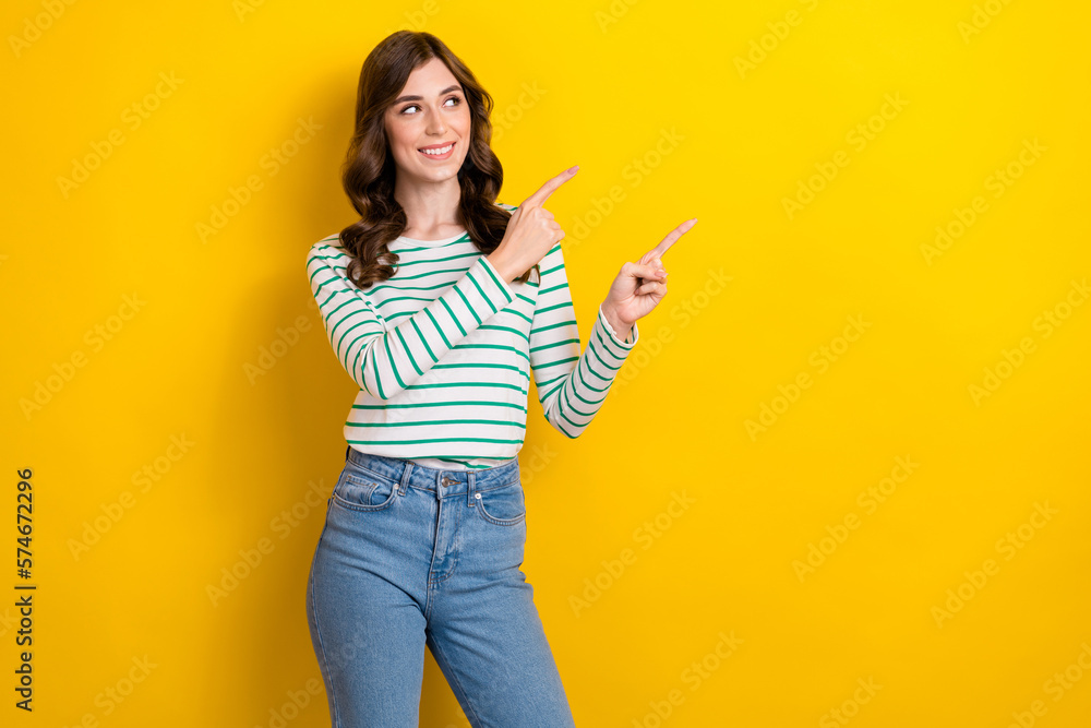 Photo of young cheerful satisfied glad lady looking directing fingers demonstrate new product cheap cost mockup isolated on yellow color background Photo of young cheerful satisfied glad lady looking directing fingers demonstrate new product cheap cost mockup isolated on yellow color background