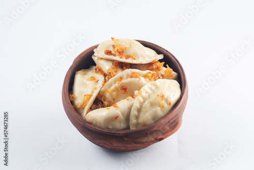 Boiled dumplings seasoned with spices in a plate on a white background.