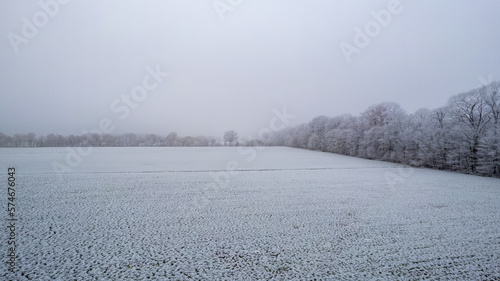 Aerial drone picture of a winter cloudy day over a snow covered fields. Winter dull day. High quality photo