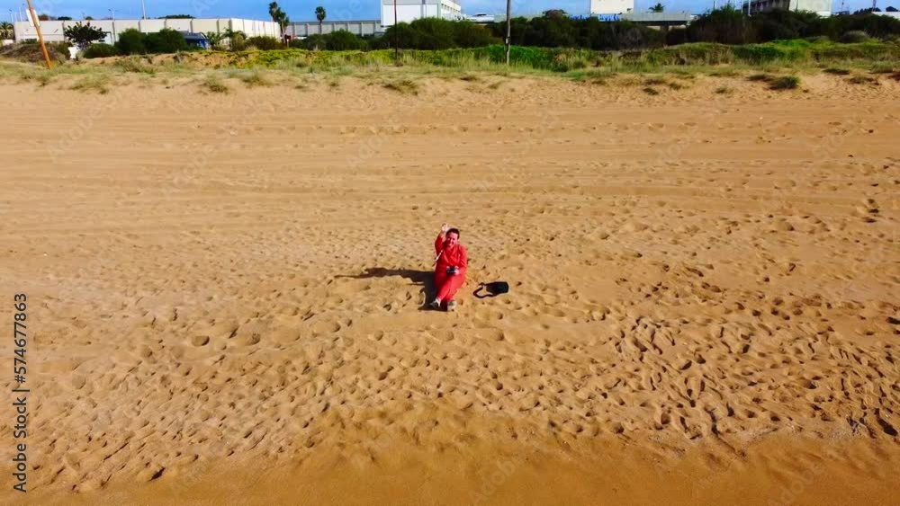girl is sitting on sandy beach and controls a drone. girl is sitting on sandy beach and controls a drone.