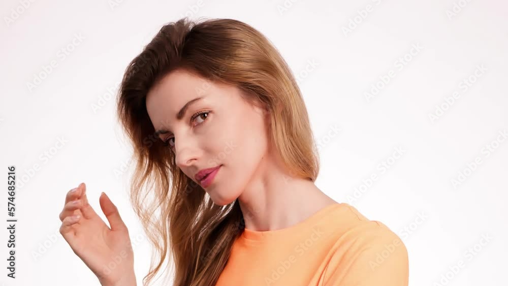Woman smiling looking at camera. Happy positive emotional blonde girl, long hair. Cheerful lady smile face, beauty self-love concept. Indoors studio, pretty young lady isolated on white background Woman smiling looking at camera. Happy positive emotional blonde girl, long hair. Cheerful lady smile face, beauty self-love concept. Indoors studio, pretty young lady isolated on white background
