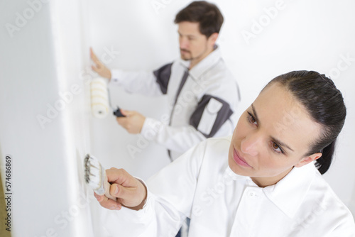 woman with colour swatch near wall in new apartment
