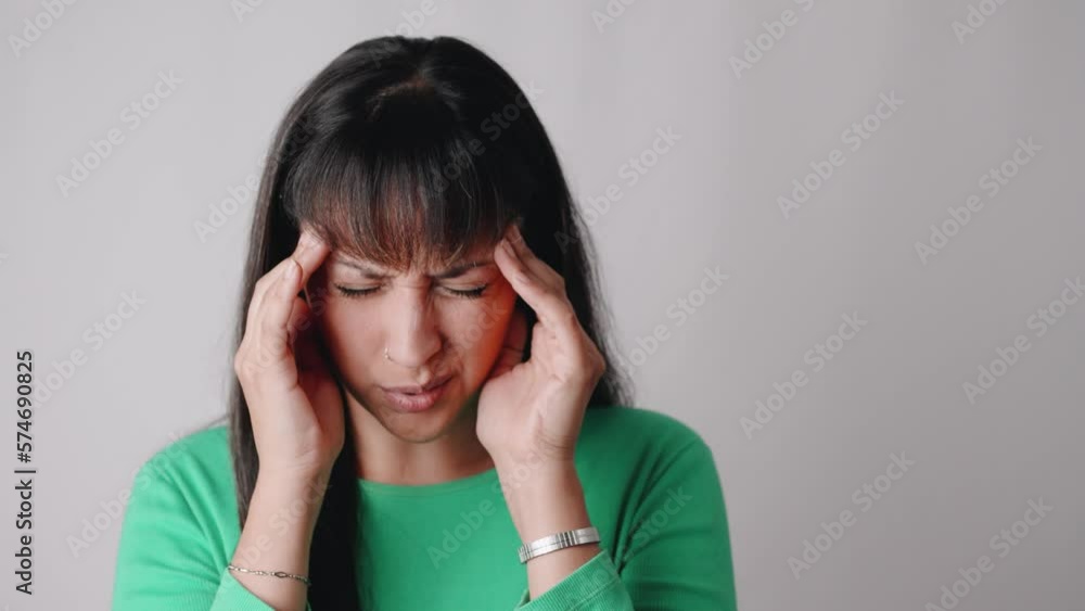 Frustrated Latin American woman holding her head while suffering from strong migraine Frustrated Latin American woman holding her head while suffering from strong migraine