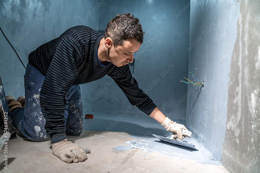 bricklayer works with trowel in room bricklayer works with trowel in room