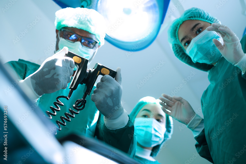 Doctor using defibrillator to patient at operating room in hospital. - obrazy, fototapety, plakaty 