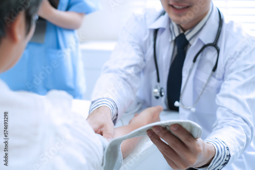 Doctor with stethoscope checking blood pressure to elderly woman patient in the hospital.