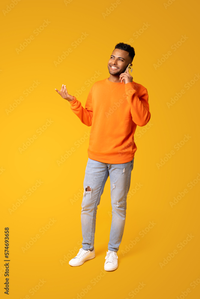 Gesturing indian man talking phone, calling to somebody, looking away with happy smile. Indoor studio shot isolated on yellow background Gesturing indian man talking phone, calling to somebody, looking away with happy smile. Indoor studio shot isolated on yellow background