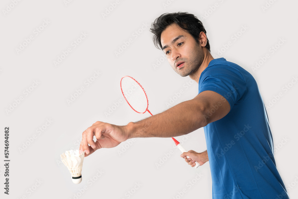 A badminton player in sportswear stands holding a racket and shuttlecock. A badminton player in sportswear stands holding a racket and shuttlecock.