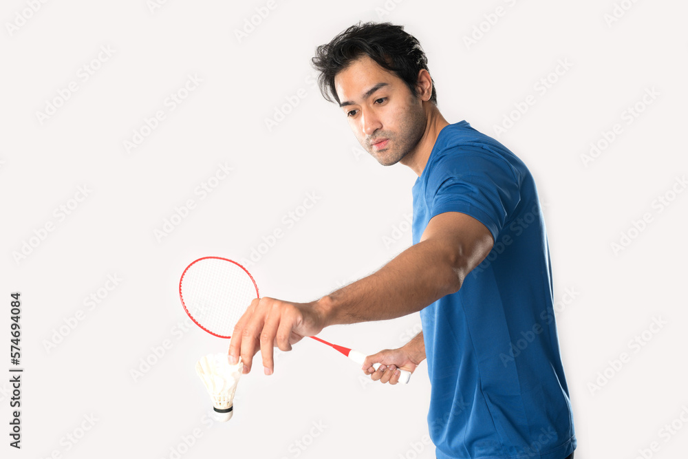 A badminton player in sportswear stands holding a racket and shuttlecock. A badminton player in sportswear stands holding a racket and shuttlecock.