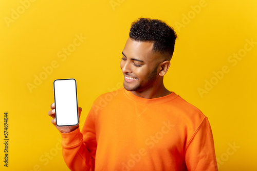 Φωτογραφία Handsome young man showing smartphone with blank screen and looking at screen, g