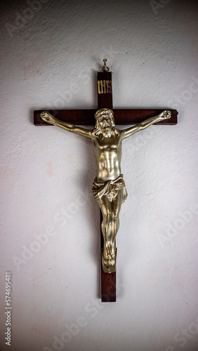 a cross hung on a white wall