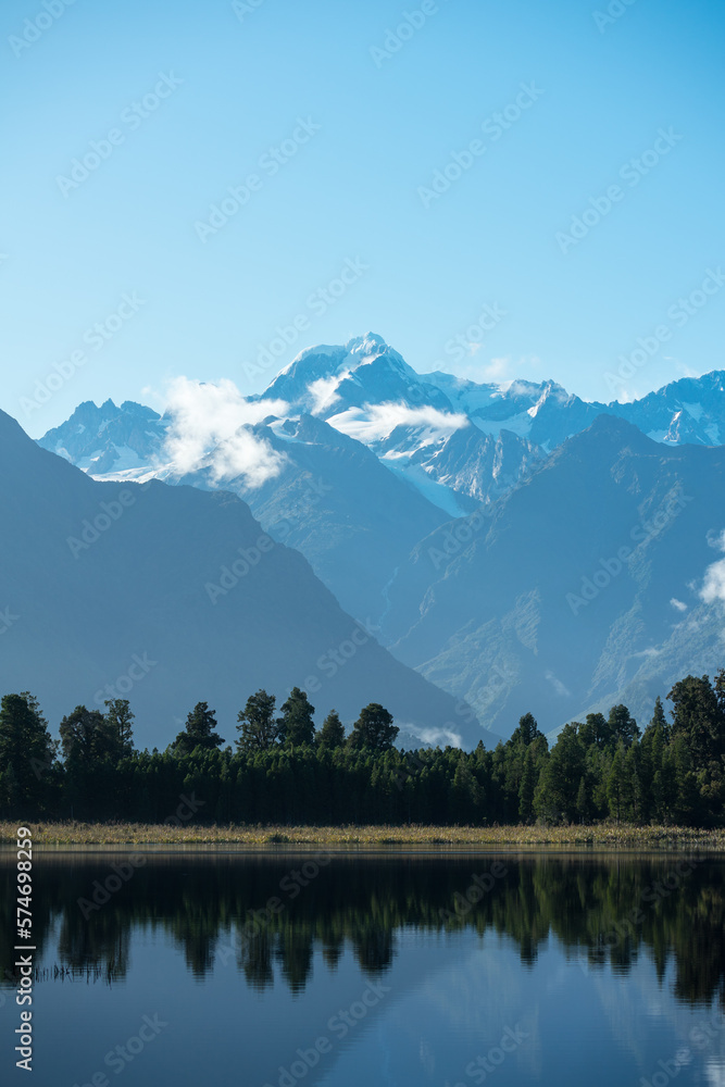 Naklejka premium Spiegelsee, Lake Matheson, in Neuseeland mit Bäumen, wolken, Gletscher und Mt Cook an der Westküste auf einem Roadtrip.