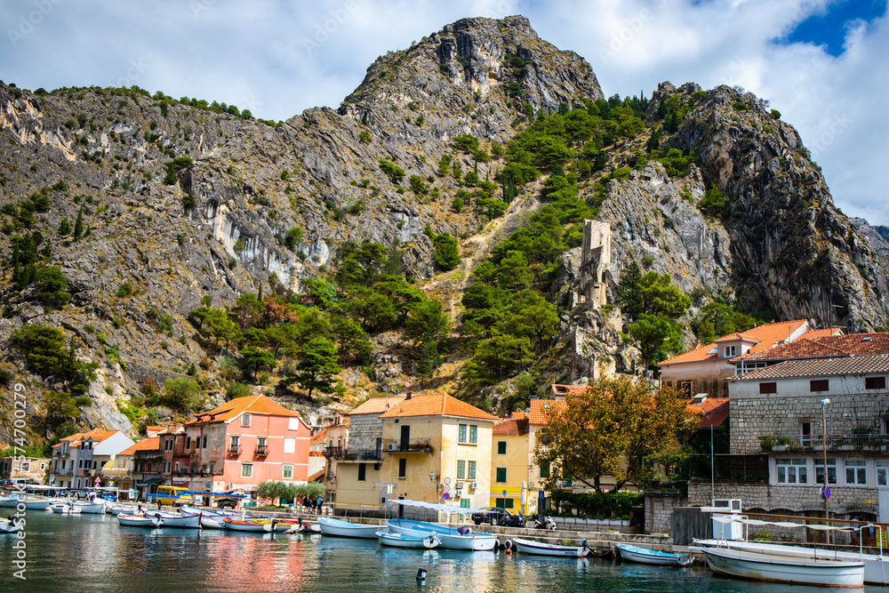 panorama of the town of omis in croatia on the adriatic coast; the famous old town at the mouth of the cetina river; old buildings surrounded by huge mountains in a canyon