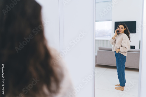 Happy woman talking on smartphone while looking at mirror Free Download Happy woman talking on smartphone while looking at mirror - GFXLoad