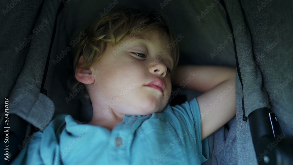 Drowsy little boy sitting inside stroller after nap. Child awake after napping Drowsy little boy sitting inside stroller after nap. Child awake after napping