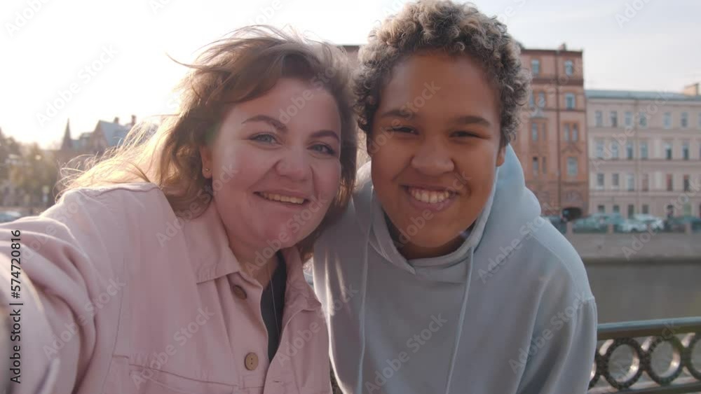Young happy lesbian lgbtq couple have video chat using mobile phone outdoors. Realtime Young happy lesbian lgbtq couple have video chat using mobile phone outdoors. Realtime