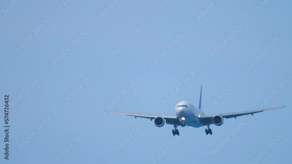Front view of jet passenger jet plane in the blue sky. Airliner approaching for landing. Unrecognizable plane flies, arriving. Tourism and travel concept Front view of jet passenger jet plane in the blue sky. Airliner approaching for landing. Unrecognizable plane flies, arriving. Tourism and travel concept