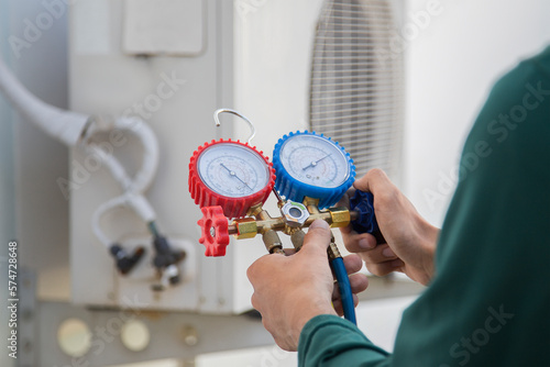 Canvas Print Air conditioning, HVAC service technician using gauges to check refrigerant and add refrigerant