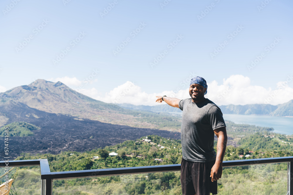 Cheerful black man admiring view of mountain