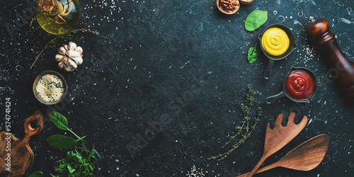 Cooking background. Spices  vegetables and herbs. On a black stone background. Top view.