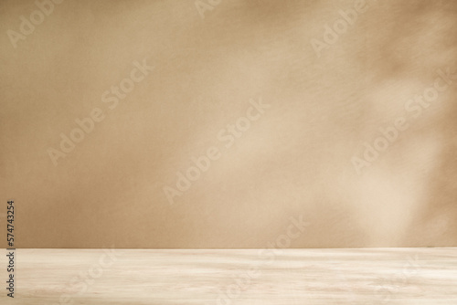 Wooden table with light and subtle texture  against beige or cream wall with sunlight