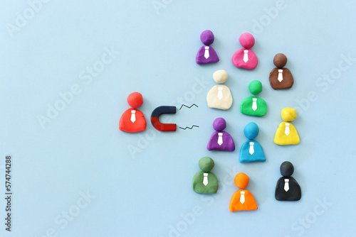 Concept image of a magnet attracting a group of people. metaphor of media influence and human resources photo