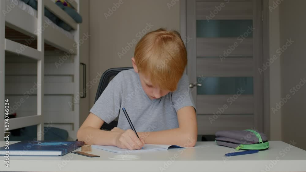 The boy does his homework. Home education. Independent work. The boy does his homework. Home education. Independent work.