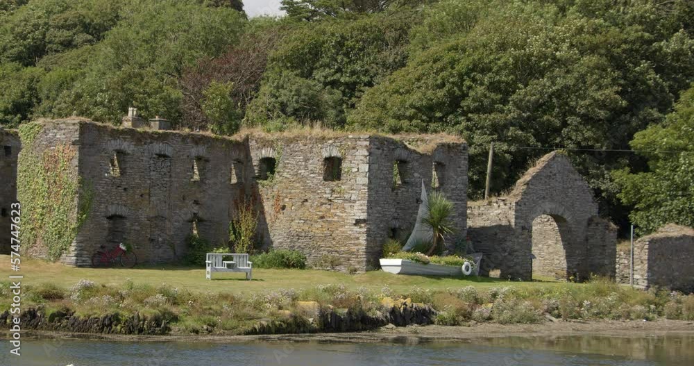 white boat with flowers near ancient stone ruins in Ireland. The ruins of Arundel Grain Store, Ring, near Clonakilty, West Cork. video. white boat with flowers near ancient stone ruins in Ireland. The ruins of Arundel Grain Store, Ring, near Clonakilty, West Cork. video.