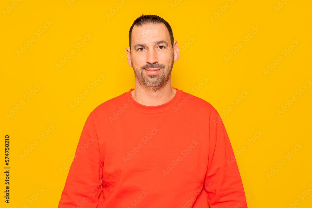 Isolated photo of a handsome man with a beard, wears a casual red sweater. He has a cheerful and relaxed expression, he is happy and content with his life Isolated photo of a handsome man with a beard, wears a casual red sweater. He has a cheerful and relaxed expression, he is happy and content with his life