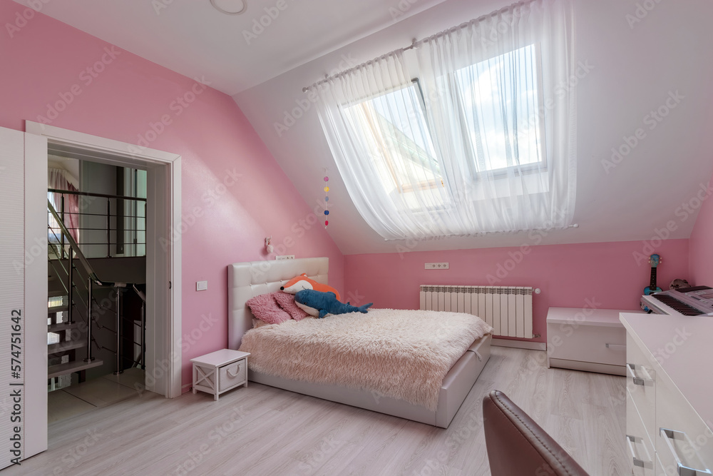 Girl bedroom with pink wall, table and toys in the attic Girl bedroom with pink wall, table and toys in the attic