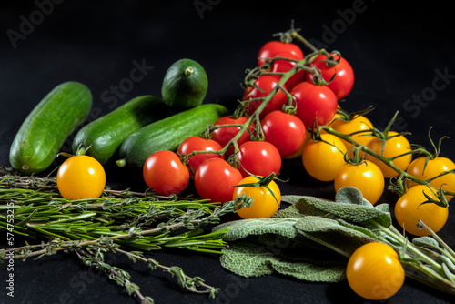 fresh vegetables and herbs on black background