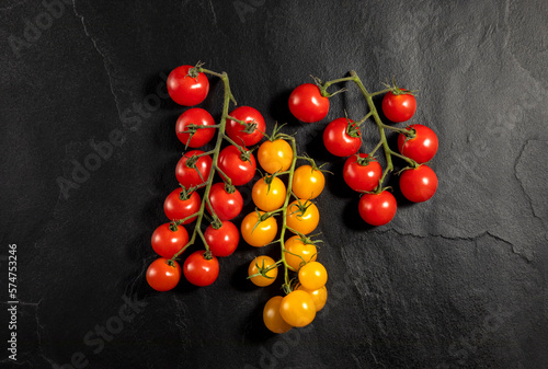 red and yellow tomatoes on black background