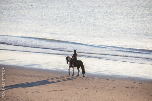 woman riding horse on sand beach