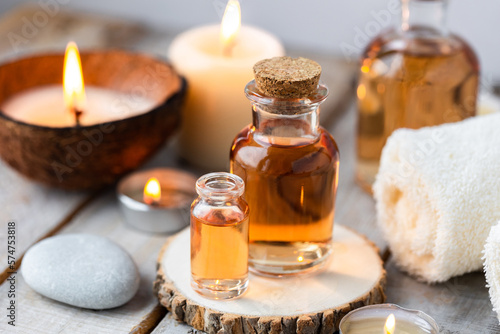 Concept of spa treatment in salon with pure organic natural oil. Atmosphere of relax  detention. Aromatherapy  candles  towel  wooden background. Skin care  body gentle treatment
