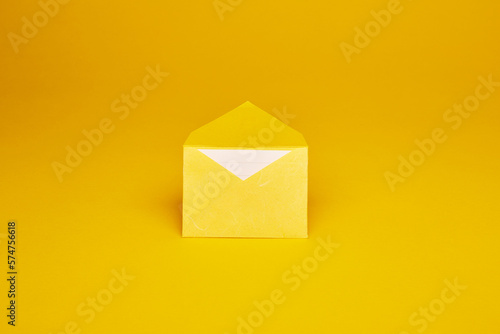 Yellow color paper office envelope with white lined sheet with copy space isolated on the bright solid fond plain yellow background