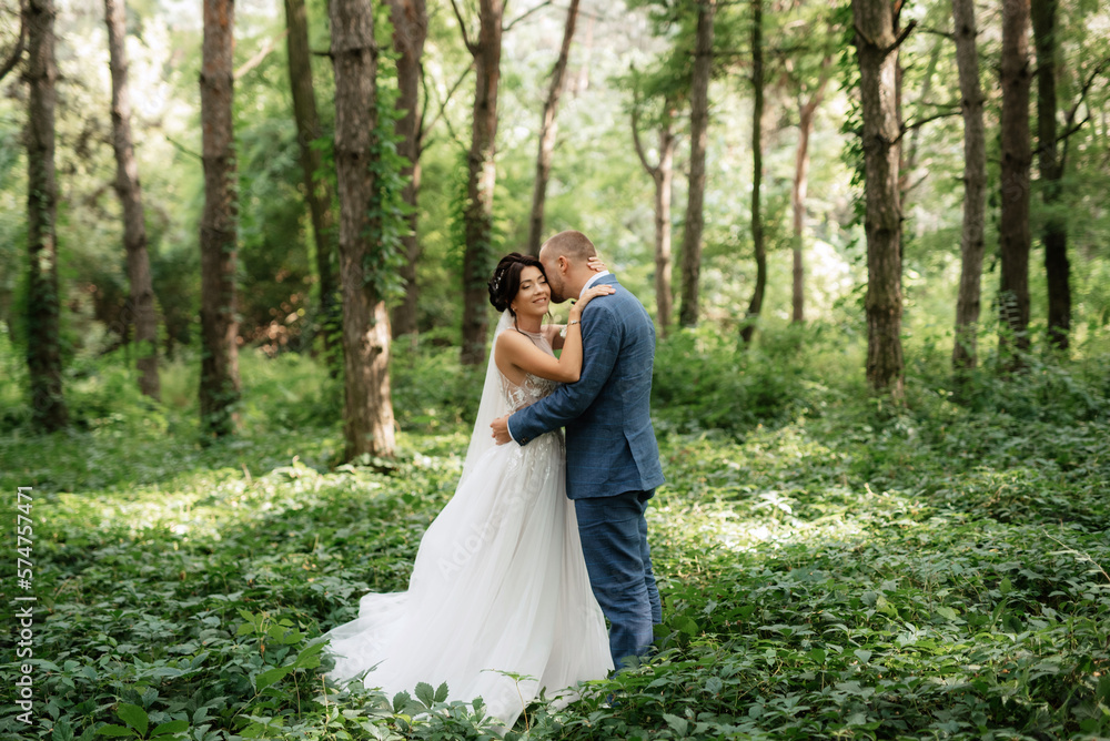 wedding walk of the bride and groom in the deciduous forest in summer wedding walk of the bride and groom in the deciduous forest in summer
