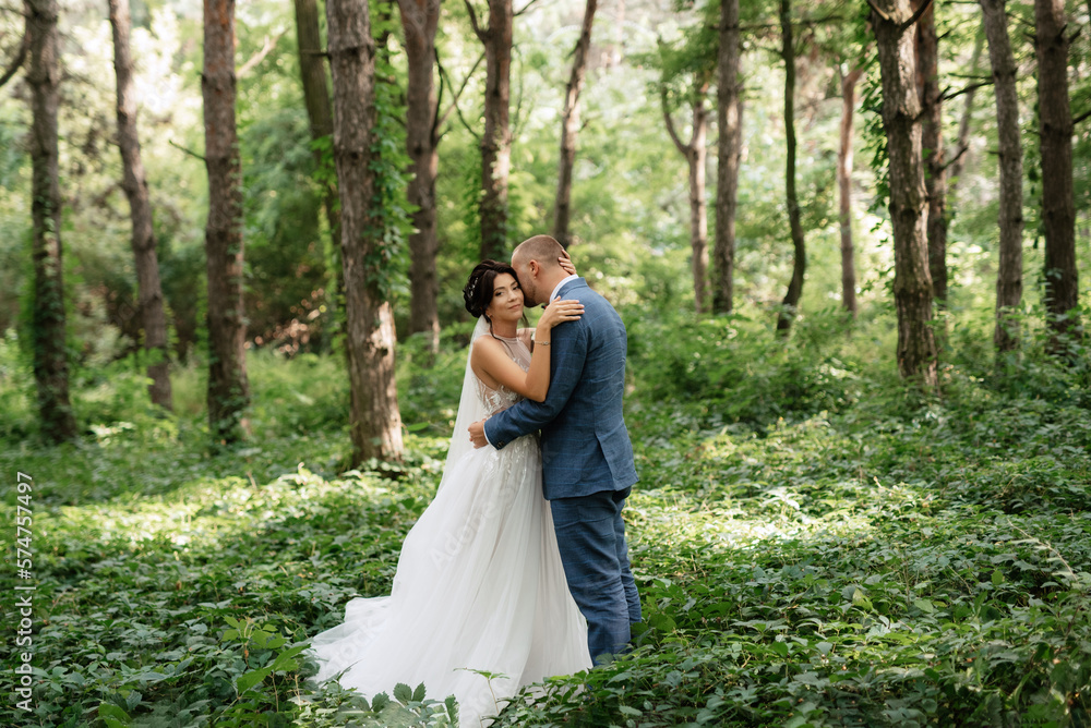 wedding walk of the bride and groom in the deciduous forest in summer wedding walk of the bride and groom in the deciduous forest in summer