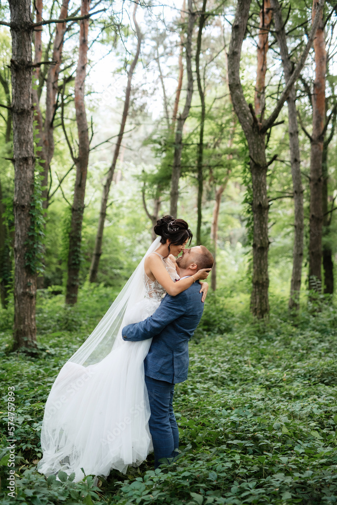 wedding walk of the bride and groom in the deciduous forest in summer wedding walk of the bride and groom in the deciduous forest in summer
