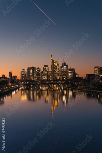 skyscrapers reflecting in the river in the city at sunset