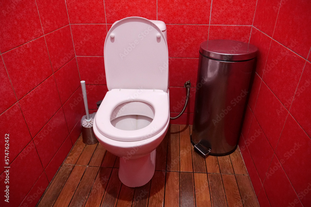 Foto de Toilet room with toilet bowl, wastebasket, toilet brush and red