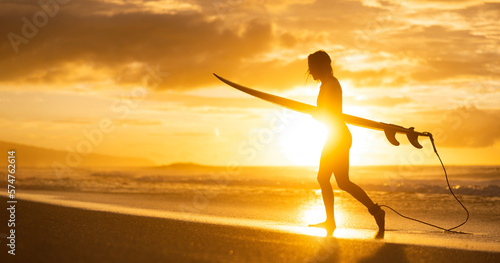 Photography A silhouette of a girl surfer on the beach at sunset