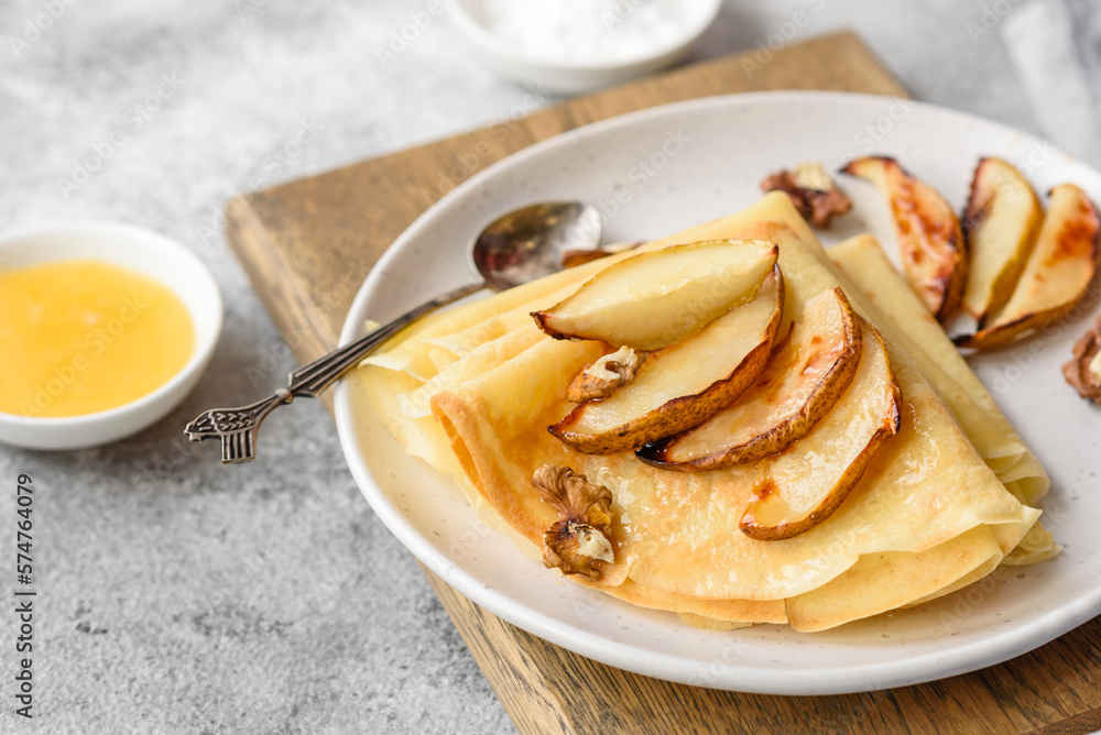 Delicious fresh baked pancakes with honey and fruits on a concrete background Delicious fresh baked pancakes with honey and fruits on a concrete background