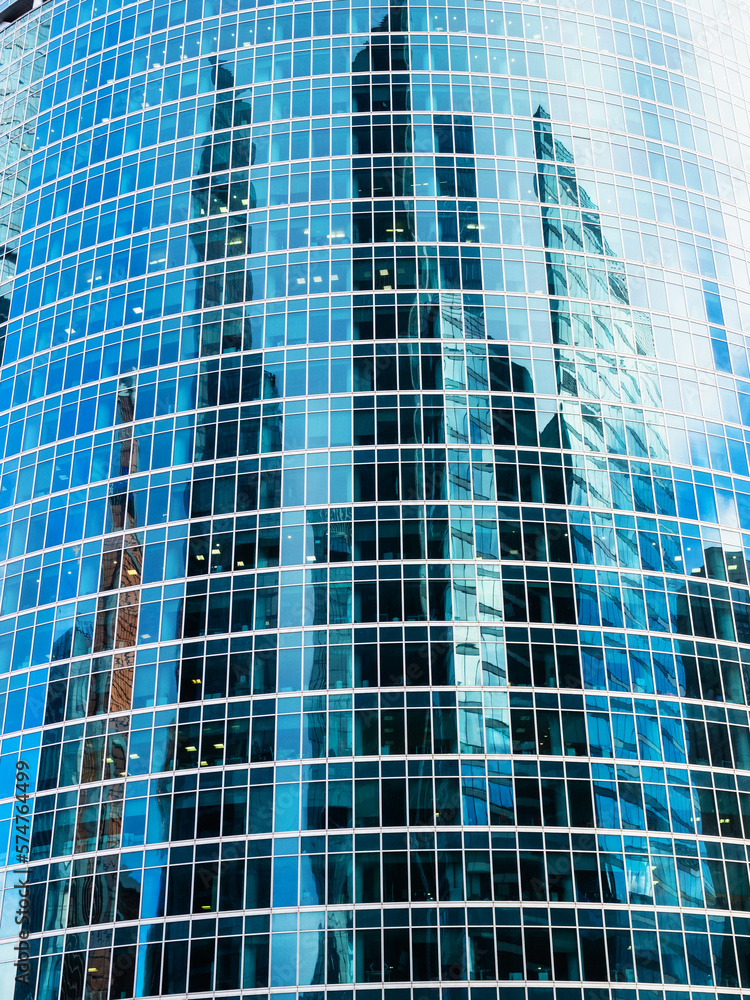 front view of glass facade of tower with reflection of skyscrapers in Moscow city district front view of glass facade of tower with reflection of skyscrapers in Moscow city district